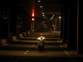 WUHAN, CHINA - FEBRUARY 01: (CHINA OUT)  An expressman drives down an empty street as he delivers packages on a bicycle on February 1, 2020 in Wuhan, Hubei province, China. The number of those who have died from the Wuhan coronavirus, known as 2019-nCoV, in China climbed to 259 and cases have been reported in other countries including the United States, Canada, Australia, Japan, South Korea, India, the United Kingdom, Germany, France, and several others.