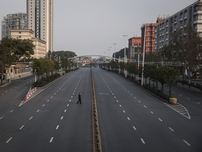 A man cross an empty highway road on Monday in Wuhan, Hubei province, China.