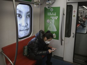 A woman wears a protective masks as she rides  on a nearly empty subway car during the evening rush period on February 10, 2020 in Beijing, China.