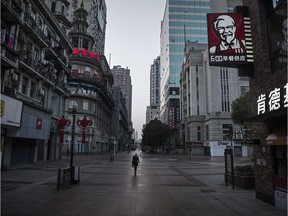 A person walks through the deserted streets of Wuhan, China on Thursday. The city has been under quarantine for 22 days because of the outrbreak of the Covid-19 virus.