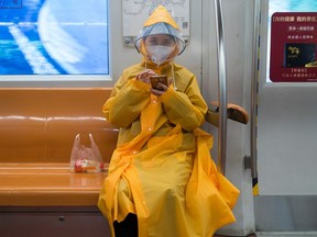 A woman wearing protective gear sits on the subway on February 10, 2020 in Beijing, China.