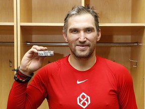 Alex Ovechkin of the Washington Capitals poses for a photo with the goal No. 700 puck.