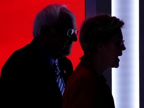Democratic 2020 U.S. presidential candidates Warren and Sanders walk on stage during a break at the tenth Democratic 2020 presidential debate at the Gaillard Center in Charleston, South Carolina.