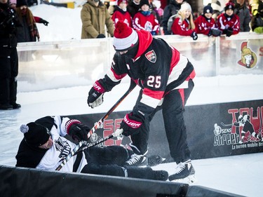 The Ottawa Senators Alumni and NHL Alumni held a shinny game at the Rink of Dreams in front of City Hall Saturday, February 8, 2020, part of the Home Town Hockey Tour. Sens Alumni Chris Neil pushes Shawn Rivers into the very short boards.   Ashley Fraser/Postmedia