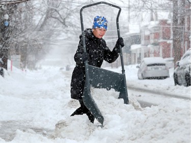 Mary Chaput really had to put her back into it to clear the snow from the front of her house in the Glebe Thursday.