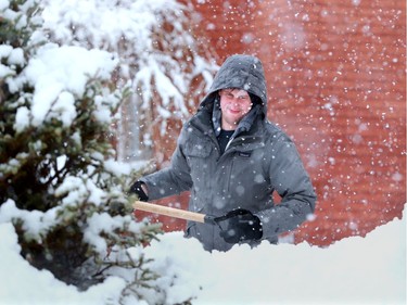 John Nyman can be seen over a waist-deep pile of snow as he dug out his pathway on Fourth Avenue Thursday. Commuters had a hard time getting around Ottawa Thursday following a huge dump of wet, slushy snow in the capital.