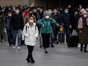 Passengers wearing facemasks arrive from different provinces at the Beijing Railway Station on February 1, 2020. - China faced deepening isolation over its coronavirus epidemic as the death toll soared to 259, with the United States and Australia leading a growing list of nations to impose extraordinary Chinese travel bans.