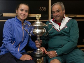 This hand out picture supplied by the Australian Open shows Sofia Kenin and her father, Alex, pose with the women's singles championship trophy in the locker room after Sofia defeated Spain's Garbine Muguruza final on Saturday.