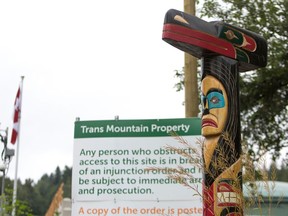 (FILES) In this file photo taken on June 20, 2019 A totem pole is pictured outside the Kinder Morgan Burnaby Terminal and Tank Farm in Burnaby, British Columbia on June 20, 2019.