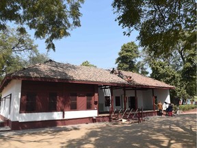 Indian workers re-arrange old roof tiles on 'Hriday Kunj' where Mahatma Gandhi stayed between 1918 - 1930, at Gandhi Ashram, in Ahmedabad on February 12, 2020. (Photo by SAM PANTHAKY / AFP)