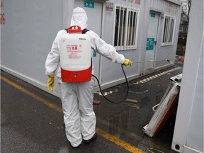 A worker disinfects between containers at the Youan Hospital in Beijing on February 14, 2020. - Youan Hospital is one of twenty hospitals in Beijing treating coronavirus patients. Six health workers have died from the COVID-19 coronavirus in China and more than 1,700 have been infected, health officials said on February 14, underscoring the risks doctors and nurses have taken due to shortages of protective gear.