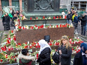 People pay pay their respect at a makeshift memorial set up at the market square (Marktplatz) in Hanau near Frankfurt am Main, western Germany on February 21, 2020, two days after a gunman killed nine in a racist attack.