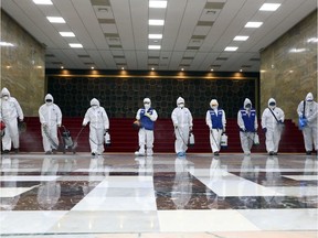 Workers from the Korea Pest Control Association spray disinfectant as part of preventive measures against the spread of the COVID-19 coronavirus, at the National Assembly in Seoul on February 25, 2020. - South Korea's parliament cancelled sessions on February 25 as it closed for cleaning after confirmation a person with the coronavirus had attended a meeting last week. It is set to reopen February 26 morning.