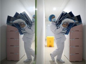 A medical worker carries protective suits at Jinyintan hospital in Wuhan, the epicentre of the novel coronavirus outbreak, in Hubei province, China February 13, 2020. Picture taken February 13, 2020.