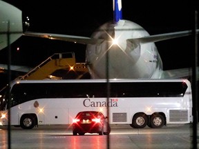 A bus waits to transport Canadian passengers of the Diamond Princess cruise ship, who tested negative after a quarantine on the ship due to the novel coronavirus outbreak, after they landed on a chartered evacuation flight from Japan, at CFB Trenton air force base.