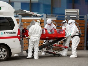 A confirmed coronavirus  patient is wheeled to a hospital at Chuncheon, South Korea, February 22, 2020.