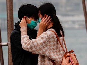 A couple wears masks as the embrace, following the outbreak of the novel coronavirus on Valentine's Day in Hong Kong, China February 14, 2020.