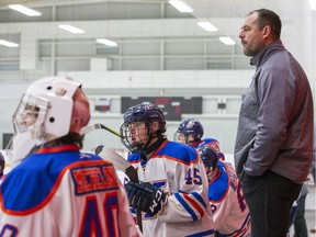 Chris Phillips stands on the bench behind his son Ben.