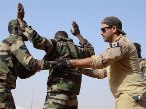 A Canadian Special Operations Regiment instructor teaches soldiers from the Niger Army how to properly search a detainee in Agadez, Niger, Feb. 24, 2014 during that year’s Flintlock exercise. (U.S. Army photo)