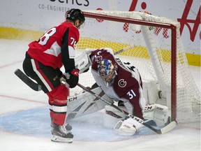 Colorado Avalanche goalie Philipp Grubauer covers the puck with Ottawa Senators center Filip Chlapik attacking in the third period at the Canadian Tire Centre.