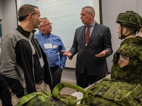 A Department of National Defence official and civilian industry representatives discuss Canadian military equipment during an event on the Soldier Operational Clothing and Equipment Modernization (SOCEM) held in Gatineau, Québec on Feb. 5. Photo: Sgt. Pat Blanchard, Canadian Army Public Affairs