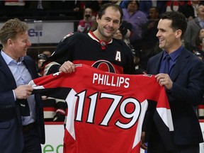 Ottawa Senators defenceman Chris Phillips has a laugh with Daniel Alfredsson and Wade Redden as he enters the Senators franchise's record book by suiting up for game No. 1,179.