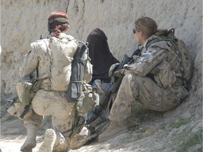 April 2008 Panjwayi, Afghanistan: Master Bombardier Jennifer Mason (right) and Corporal Tatyana Danylyshyn (left) of the Kandahar Provincial Reconstruction Team speak to an Afghan woman during a foot patrol.