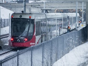 An idle LRT sits on the track slightly east of the St Laurent station due to a malfunction.  No passengers appear to be on the train but difficult to tell from my angle.