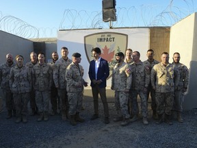 Prime Minister Justin Trudeau stands with Chief of Defence Staff Jonathan Vance visits with Canadian troops at Camp Canada at Ali al Salem Air Base in Kuwait on Monday, Feb. 10, 2020.