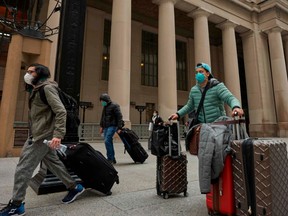 Travellers in masks leave Union Station in Toronto, Ontario on March 24, 2020.