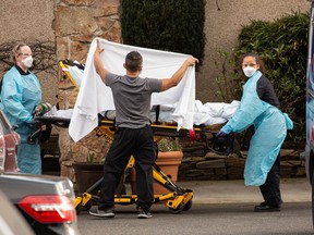 Healthcare workers transport a patient on a stretcher into an ambulance at Life Care Center of Kirkland in Kirkland, Washington. Dozens of staff and residents at Life Care Center of Kirkland are reportedly exhibiting coronavirus-like symptoms, with two confirmed cases associated with the nursing facility reported so far.
