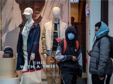 A young man wears a face mask whilst standing outside a shop on Oxford Street as the outbreak of coronavirus intensifies on March 14, 2020 in London, England.