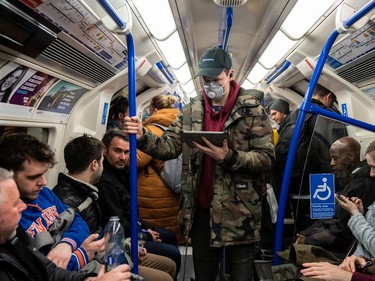 A man wears a face mask on the London underground as the outbreak of coronavirus intensifies on March 14, 2020 in London, England. Many Londoners and tourists are continuing they daily activities whilst mass gatherings could be banned in the UK from as early as next weekend as the outbreak of coronavirus intensifies. Many nations in Europe have already introduced strict travel bans and limits on their citizens daily lives whilst the United States has suspended incoming travel from European countries.