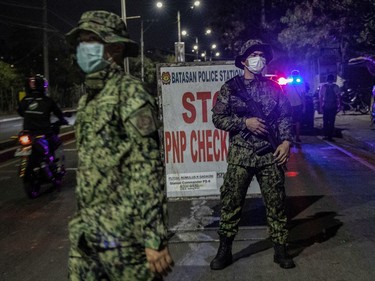 Police officers are seen wearing facemasks as they stand guard at a checkpoint as authorities begin implementing a lockdown on Manila on March 15, 2020 in the outskirts of Metro Manila, Philippines. The Philippine government is placing some 12 million people in the capital Manila on lockdown as well as suspending government work for a month to prevent the spread of COVID-19. As of Saturday evening, the Philippines' Department of Health has confirmed 111 cases of the deadly coronavirus in the country, with at least 8 recorded fatalities.