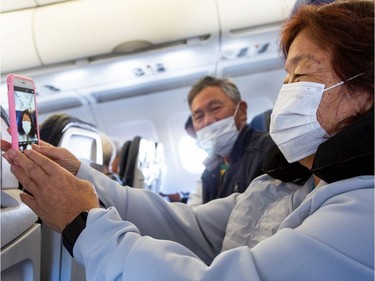 A pessenger takes a selfie while wearing a protective face mask in a airplane before take-off at the Phoenix International Airport on March 14, 2020 in Phoenix, Arizona. Passengers are wearing masks to avoid the spread of the coronavirus (COVID-19).
