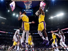 LeBron James of the Los Angeles Lakers grabs a rebound in front of Anthony Davis during a 104-102 loss to the Brooklyn Nets at Staples Center on March 10, 2020 in Los Angeles, California.