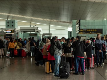 Travelers queue at the departures terminal of the Airport of Barcelona on March 14, 2020 in Barcelona, Spain. on March 14, 2020 in Barcelona, Spain.