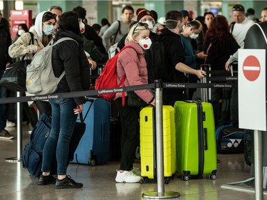 Travelers wearing protective masks arrive at the departures terminal of the Airport of Barcelona on March 14, 2020 in Barcelona, Spain. on March 14, 2020 in Barcelona, Spain.