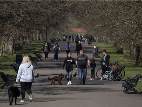 Members of the public walk through Greenwich Park on March 25, 2020 in London, England. British Prime Minister, Boris Johnson, announced strict lockdown measures urging people to stay at home and only leave the house for basic food shopping, exercise once a day and essential travel to and from work. The Coronavirus (COVID-19) pandemic has spread to at least 182 countries, claiming over 10,000 lives and infecting hundreds of thousands more.