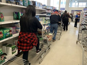 A long lineup of customers waiting to pay was typical of the Real Canadian Superstore in Westboro on Friday as people stocked up because of coronavirus fears.
