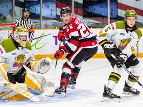Netminder Joe Verbetig (1) and defenceman Pacey Schleuting (5) of the North Bay Battalion bracket Alec Belanger of the Ottawa 67's in front of the net during an Ontario Hockey League game against the North Bay Battalion at TD Place arena in Ottawa on Sunday, Feb. 9, 2020.