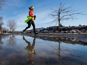 A woman jogs along the Queen Elizabeth Driveway on a warm winter day in Ottawa.