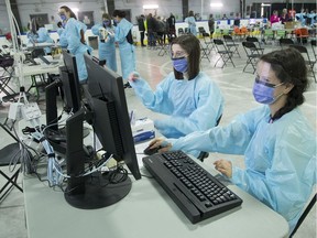 Public health workers wait for patients at Ottawa's assessment centre, at Brewer arena location.