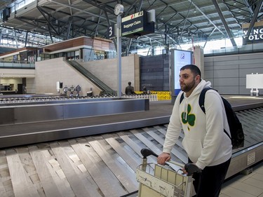 Steve Marcus, a professional basketball coach working with a team in St John's NFLD, waits to pick up his bags before renting a car and heading home to Boston, Mass, as COVID-19 has shut down most airline travel and all sporting activities around the world.