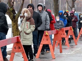About 30 people stood waiting in the rain to be tested at Ottawa's COVID-19 testing centre at Brewer Arena Tuesday.