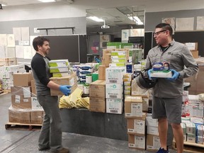 Algonquin College is donating thousands of masks, gloves and other protective equipment to hospitals and loaning out its ventilators for COVID-19 response. Above are Kyle Jamieson, shipping and receiving clerk, right, and Robert Goulet, supply clerk.