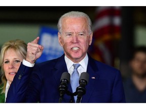 In this file photo taken on March 3, 2020 Democratic presidential hopeful former Vice President Joe Biden, flanked by his wife Jill, addresses a Super Tuesday event in Los Angeles. -