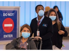 Passengers wear face masks to protect against the COVID-19 (Coronavirus) after arriving at the airport in Los Angeles, California on March 5.