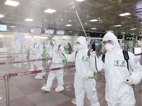 South Korean soldiers wearing protective gear spray disinfectant to help prevent the spread of the COVID-19 coronavirus, at the Daegu International Airport in Daegu on March 6, 2020. - South Korea's total reported infections -- the largest figure outside China, where the virus first emerged -- rose to 6,593 on March 6, the Korea Centers for Disease Control and Prevention said. (Photo by - / YONHAP / AFP) / - South Korea OUT / REPUBLIC OF KOREA OUT  NO ARCHIVES  RESTRICTED TO SUBSCRIPTION USE