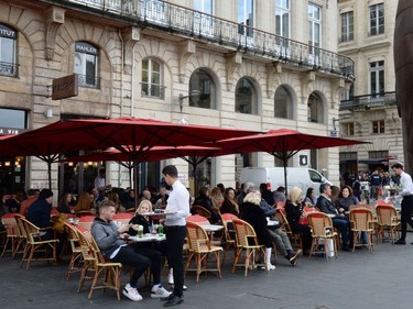 People sit on the terrace of a cafe in Bordeaux amid the outbreak of COVID-19, caused by the novel coronavirus, on March 14, 2020 and despite the authorities' recommendations to limit gatherings.